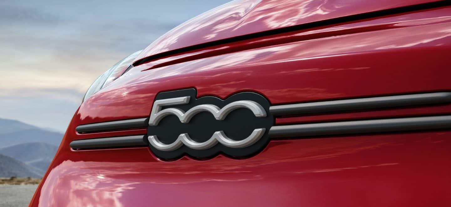 Display A close-up of the 500 badge on the front fascia of a red 2023 Fiat 500X Sport.