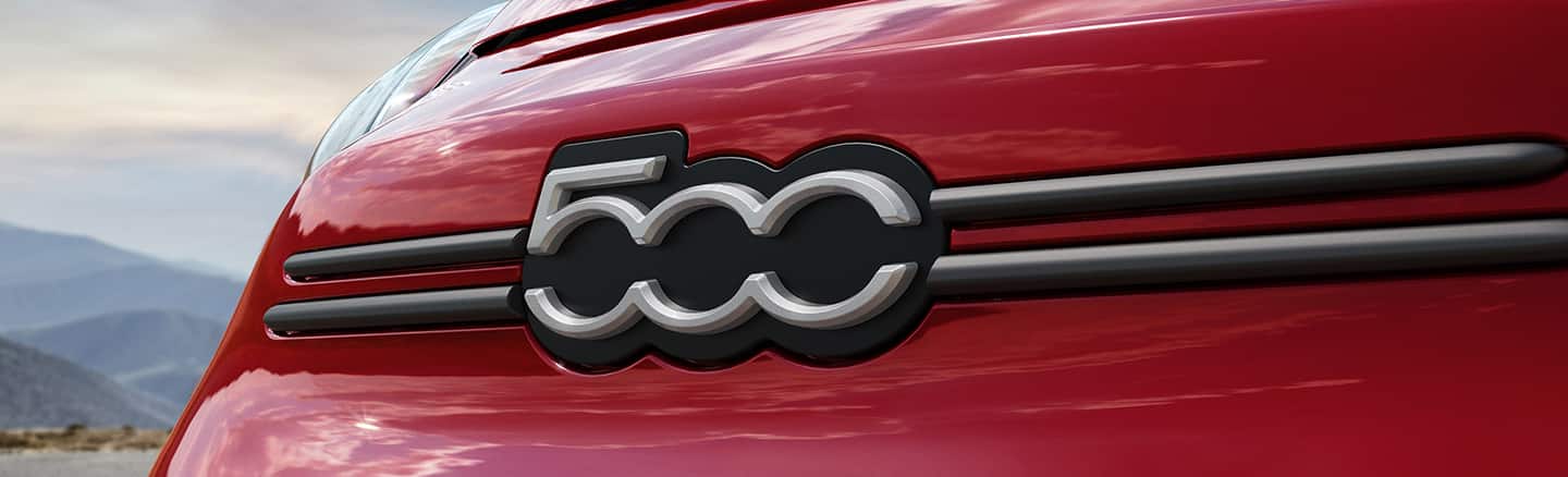 Close up shot of the front grill on a red 500x with focus on the Fiat badge.