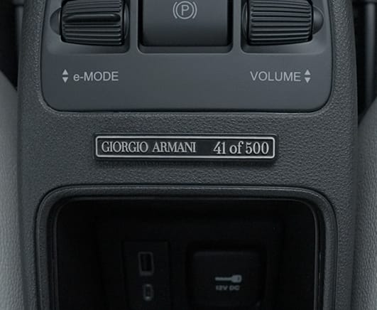 Ángulo trasero del lado del conductor de un Fiat 500e Giorgio Armani Collector's Edition 2025 en verde oscuro.