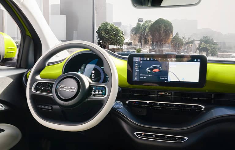 The front row of the 2025 Fiat 500e Icona with white seats, steering wheel and door panels and lime green dash and exterior mirror caps.