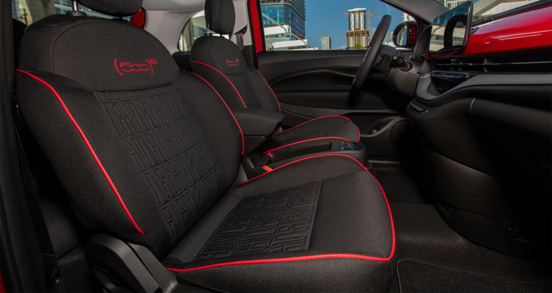 The front seats in the 2025 Fiat 500e Red.