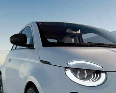 A white 2026 Fiat 500e Icona focusing on the passenger-side front end.
