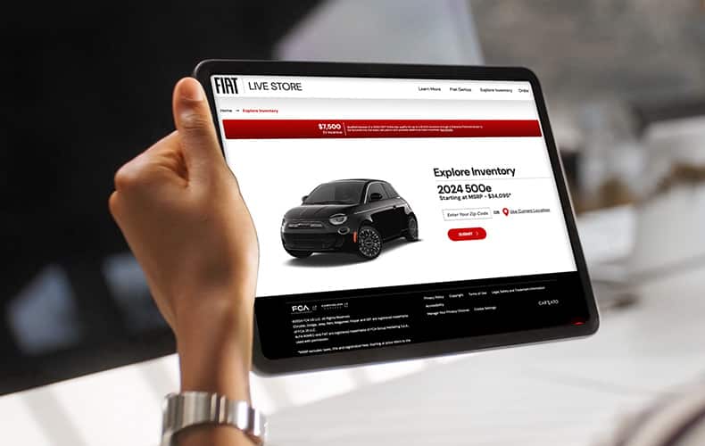 A woman holding a tablet displaying the Fiat Live Store.