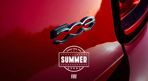 A close-up angle of a 2024 Fiat 500e logo.