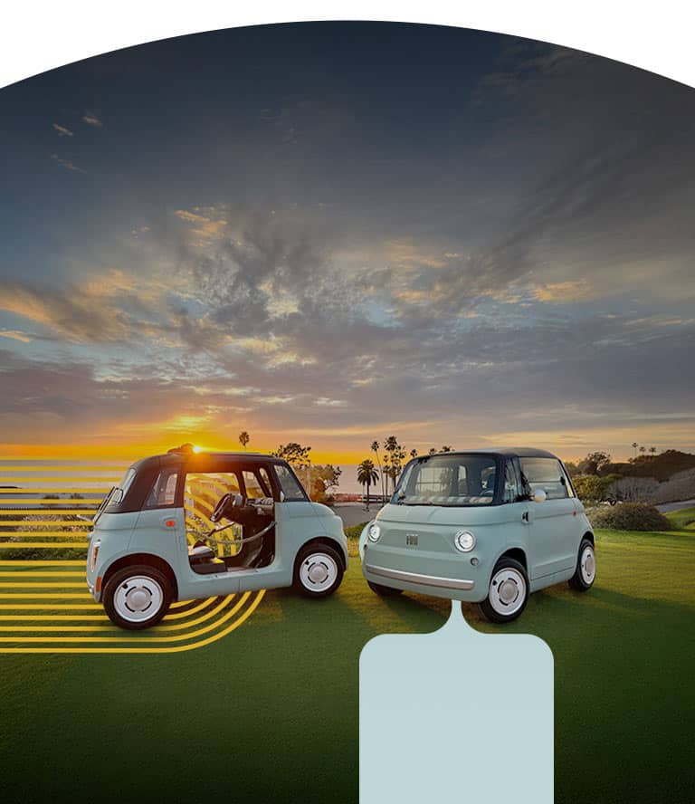 A driver-side front angle of a mint green Fiat Topolino Dolcevita with door ropes and its soft top rolled up.